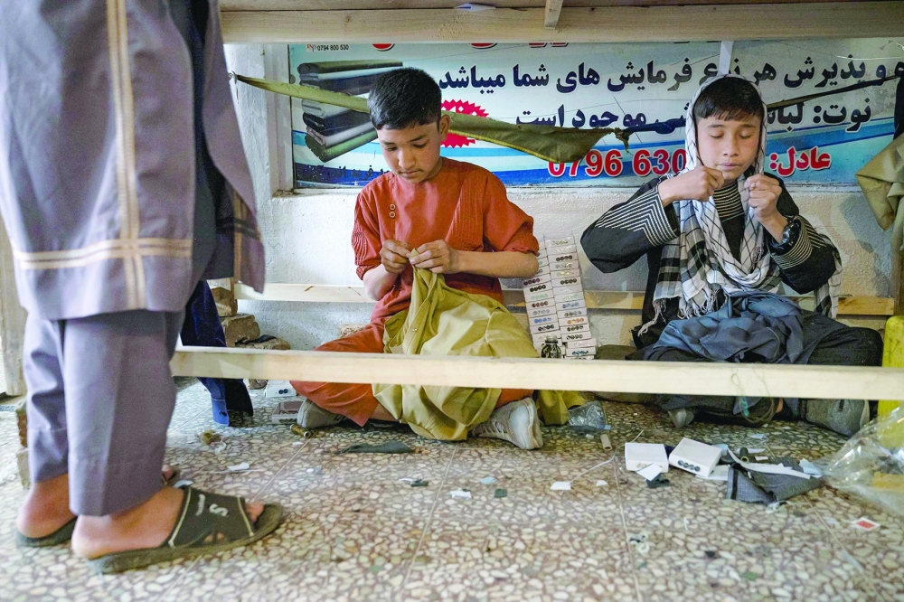 Afghan boys sew clothes ahead of Eid al-Fitr, which marks the end of the Muslim holy fasting month of Ramadan at a tailor workshop in Kabul on April 7, 2024.