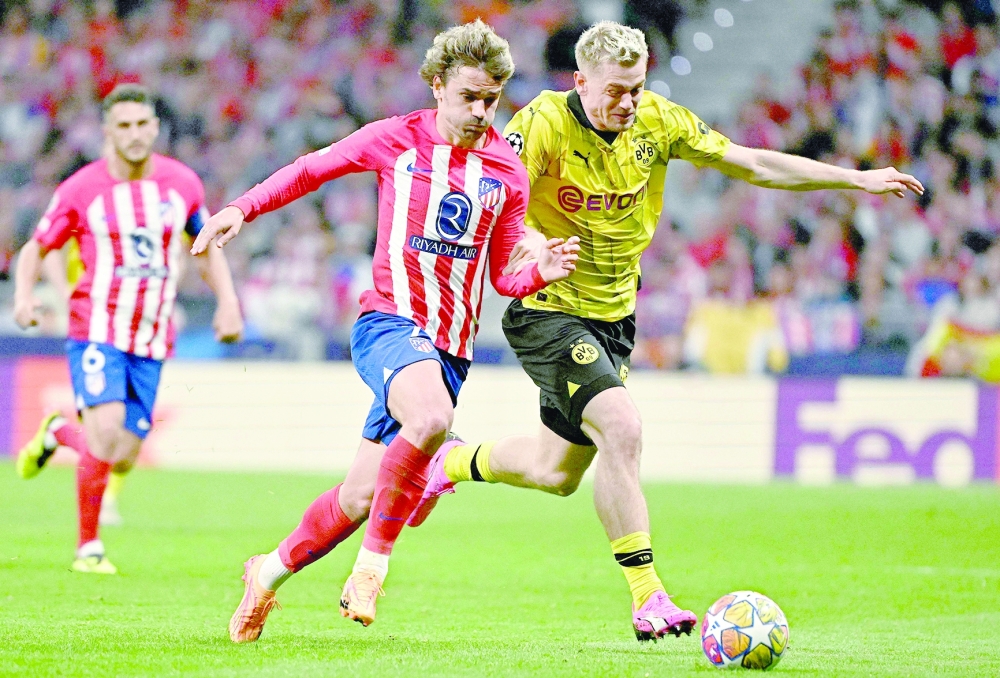 Dortmund's Norwegian defender #26 Julian Ryerson (R) fights for the ball with Atletico Madrid's French forward #07 Antoine Griezmann during the UEFA Champions League quarter final first leg football match between Club Atletico de Madrid and Borussia Dortmund at the Metropolitano stadium in Madrid on April 10, 2024.