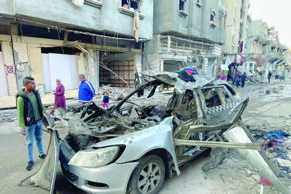 Onlookers check the car in which three sons of Hamas leader Ismail Haniyeh were reportedly killed in an Israeli air strike. - AFP