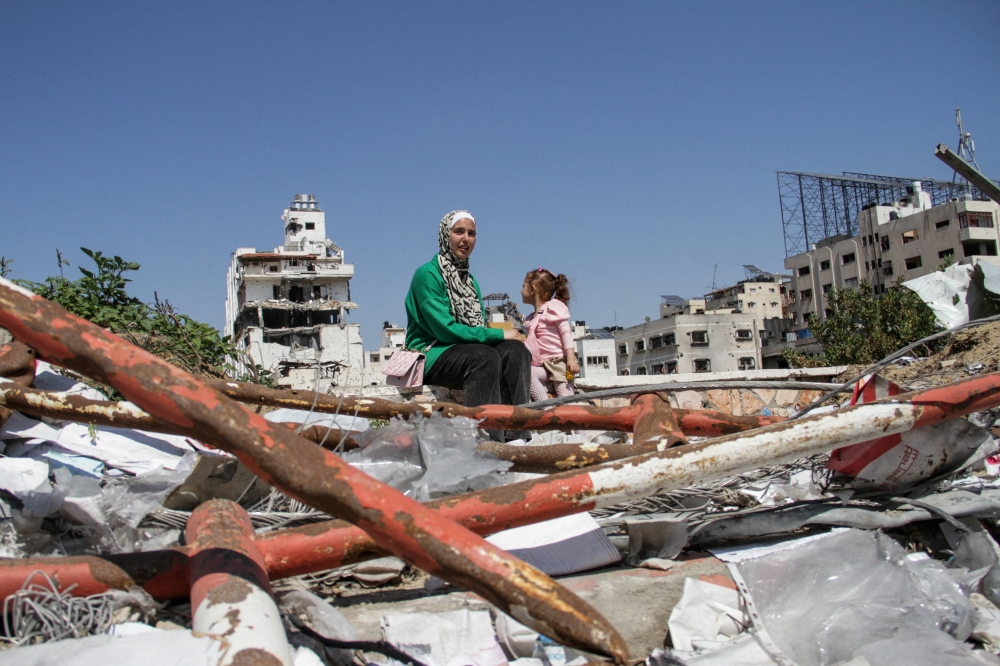 People sit amid rubble during Eid Al Fitr, amid the ongoing conflict in Gaza City on Friday. - Reuters