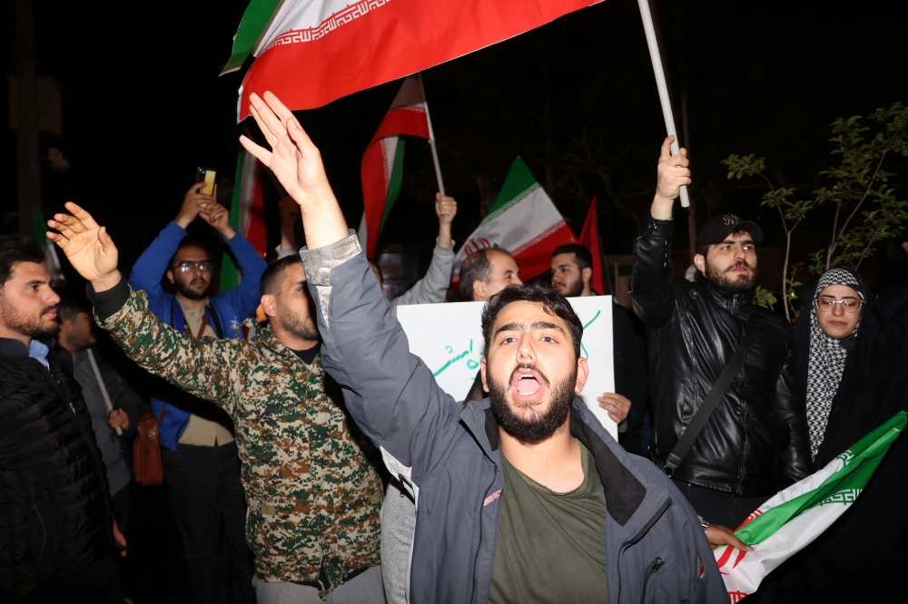 Iranian demonstrators react after the IRGC attack on Israel, during an anti-Israeli gathering in front of the British Embassy in Tehran