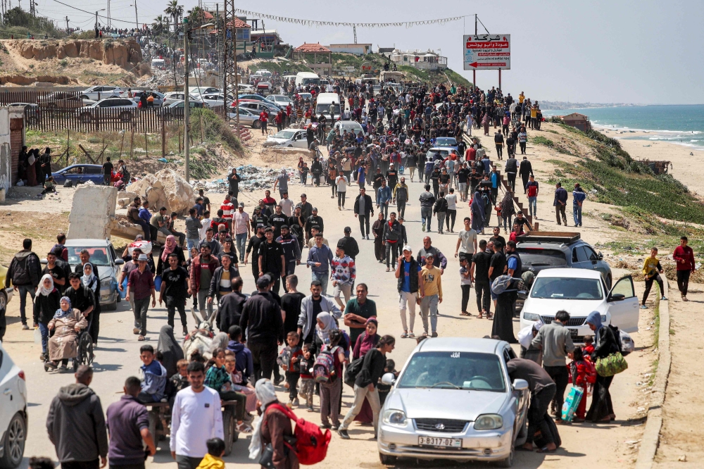 Displaced Palestinians take the coastal Rashid road to return to Gaza City. — AFP
