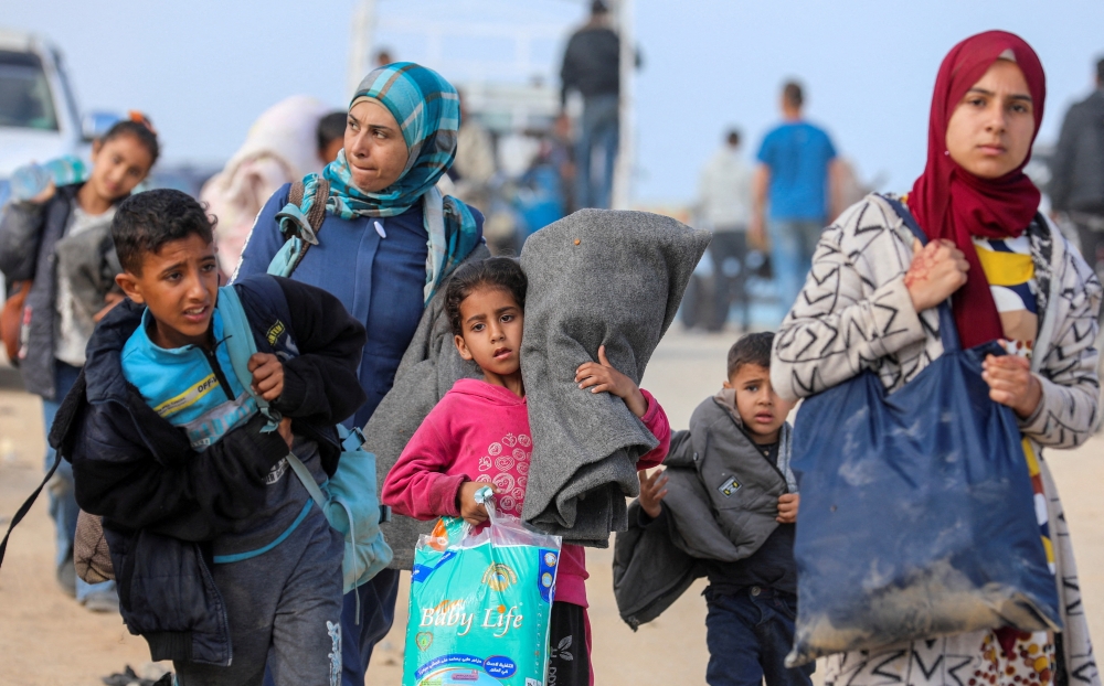Displaced Palestinians make their way as they attempt to return to their homes in north Gaza. — Reuters 
