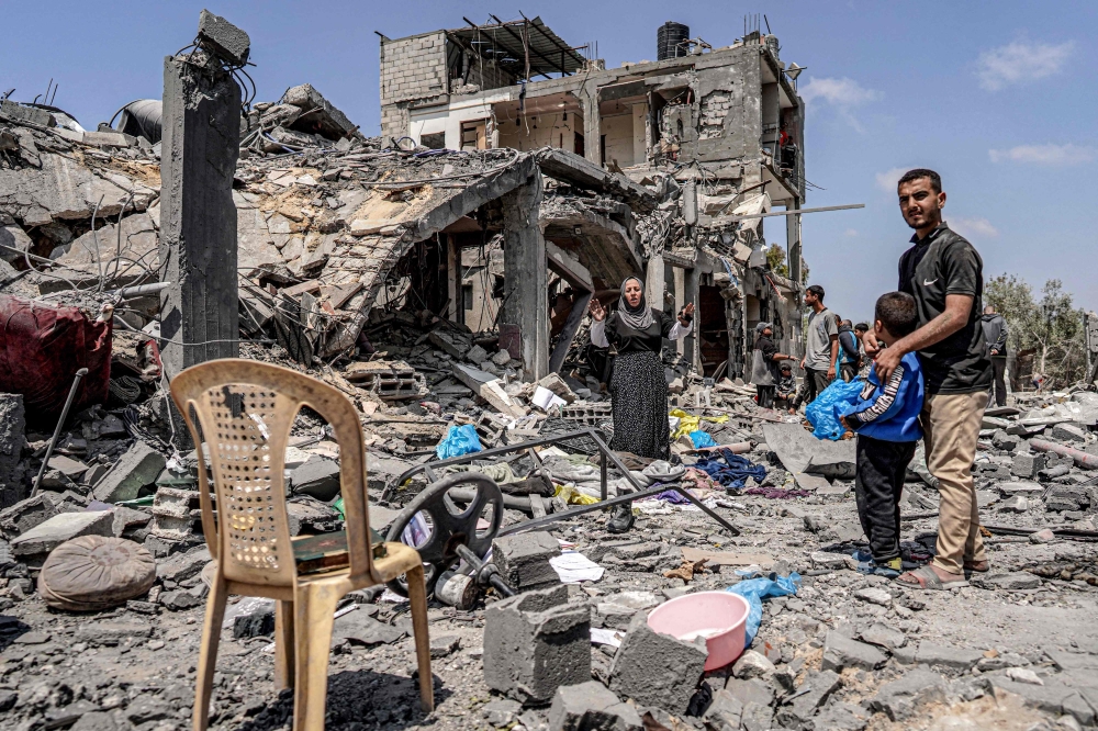 People react as they search through the rubble of a collapsed building in the eastern side of the Maghazi camp. — AFP 