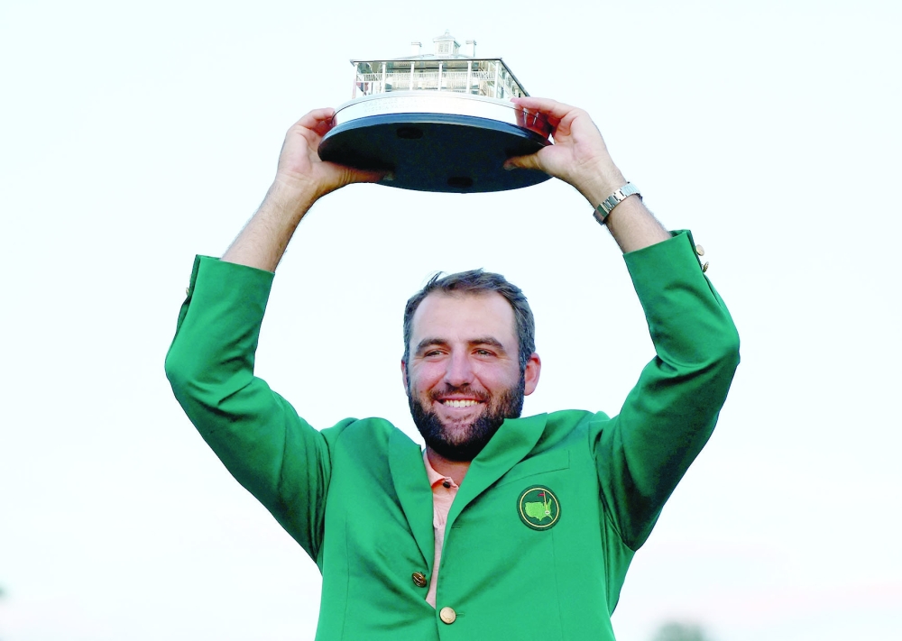 Scottie Scheffler of the US celebrates with his green jacket and the trophy after winning The Masters.