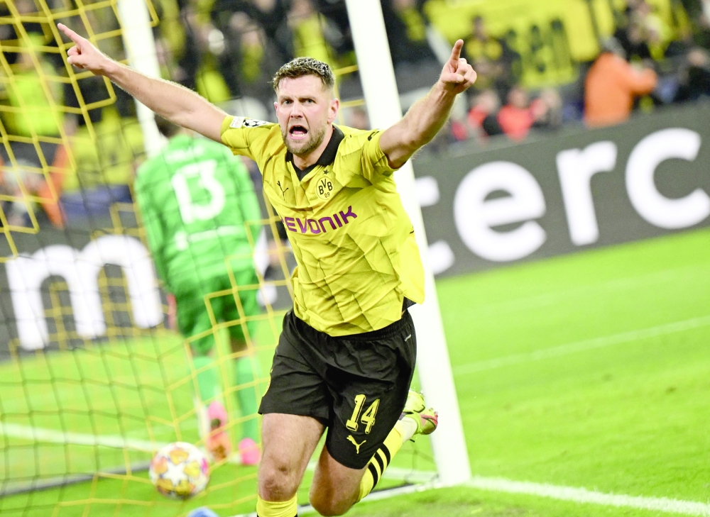 Dortmund's German forward #14 Niclas Fuellkrug celebrates scoring his team's third goal during the UEFA Champions League quarterfinal second leg football match between Borussia Dortmund and Atletico Madrid in Dortmund, western Germany on April 16, 2024.  (Photo by INA FASSBENDER / AFP)