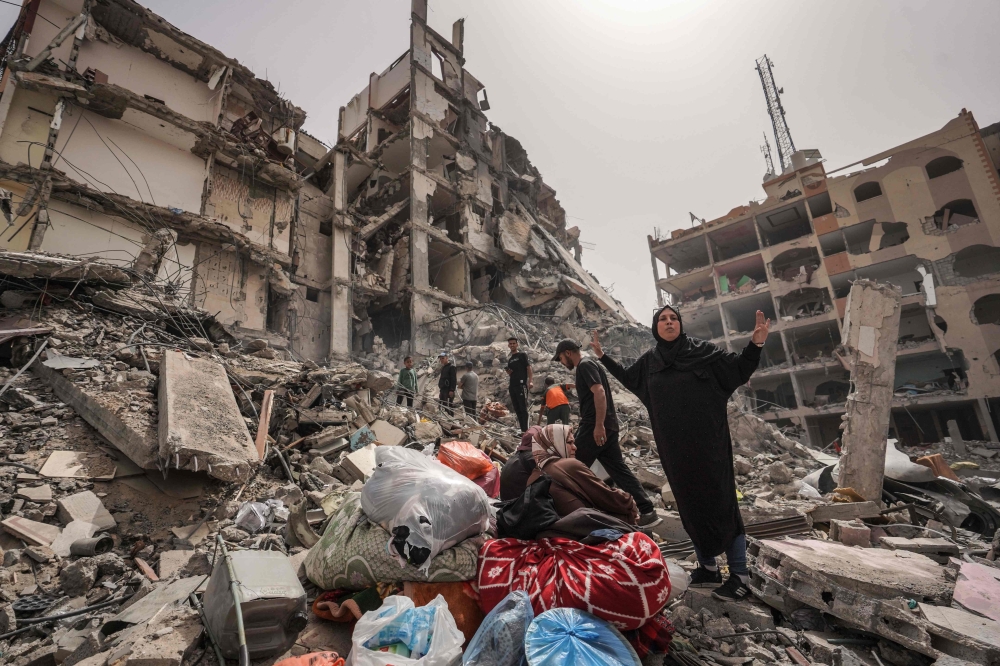 Palestinians inspect the damage to a building in the city of Nuseirat in the central Gaza Strip on Thursday. — AFP