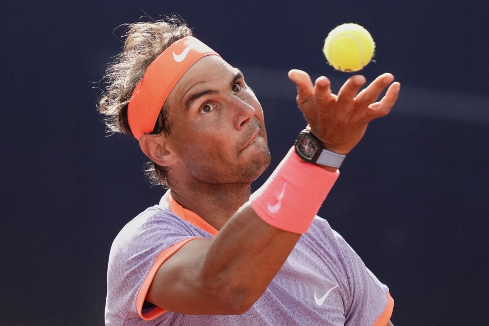 TOPSHOT - Spain's Rafael Nadal serves the ball to Australia's Alex De Minaur during the ATP Barcelona Open "Conde de Godo" tennis tournament singles match at the Real Club de Tenis in Barcelona, on April 17, 2024. (Photo by Pau BARRENA / AFP)

