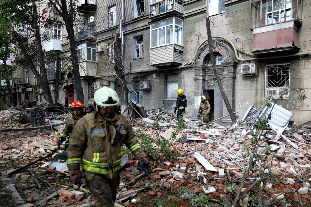 Ukrainian rescuers work in the courtyard of a residential building damaged as a result of a missile attack 