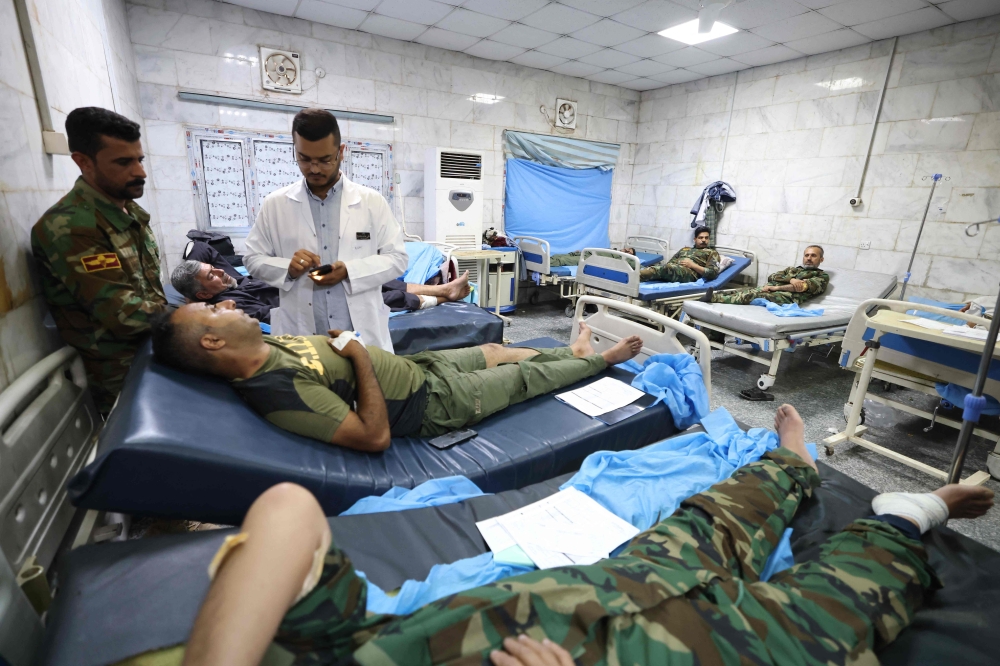 Iraqi military personnel receive treatment at a hospital in Hilla in the central province of Babylon. — AFP 