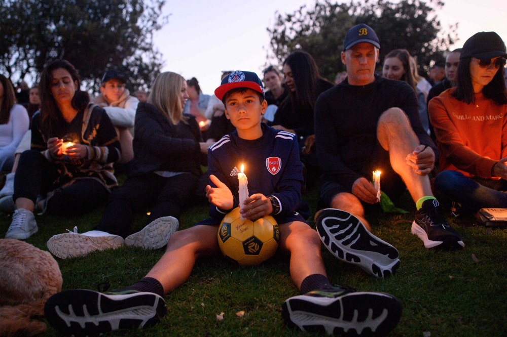 People attend a candlelight vigil for the victims of the Bondi Junction Westfield shopping centre in Sydney. — AFP 