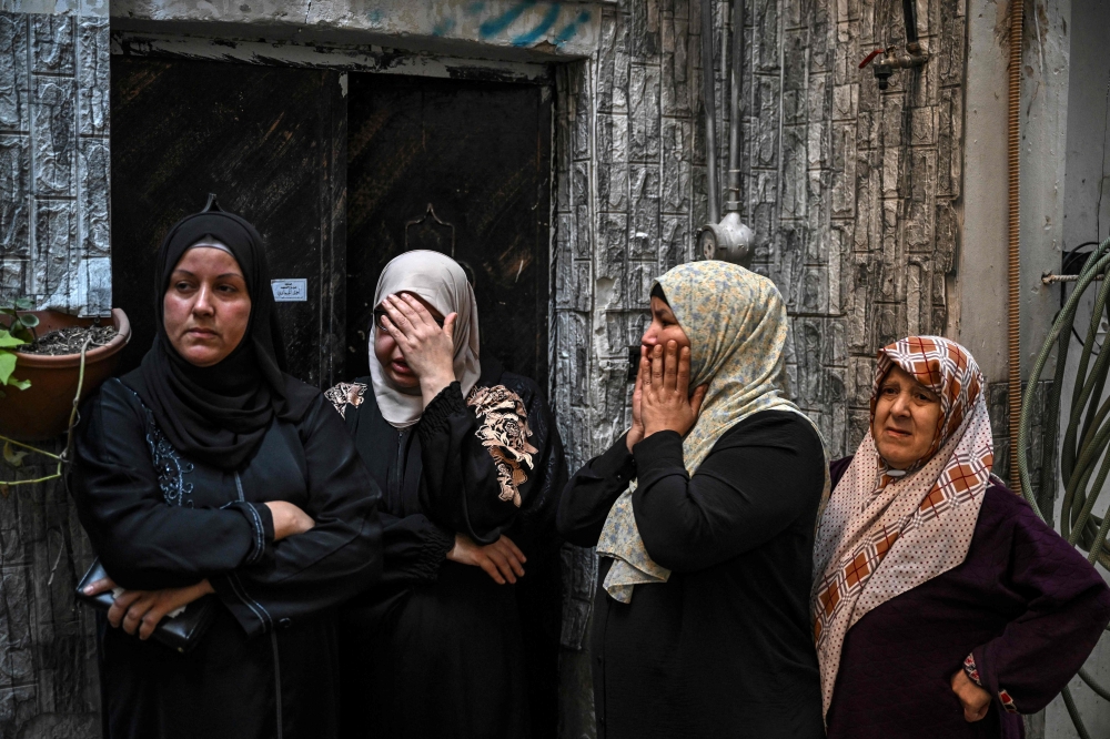 Women react as they watch the funeral procession of a man killed in an Israeli raid in the Nur Shams camp for Palestinian refugees in the occupied West Bank. — AFP 