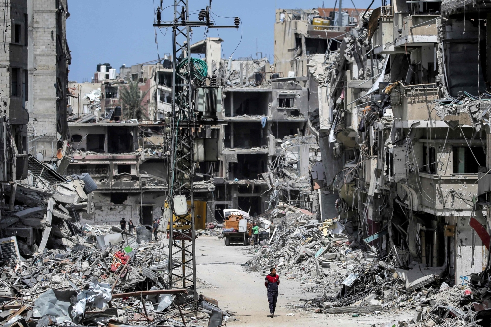 A man walks past destroyed buildings in Khan Yunis in the southern Gaza Strip. — AFP 