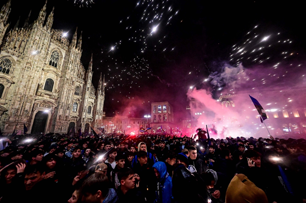 Inter Milan's supporters celebrate by the Duomo in central Milan after they won the 2024 Scudetto championship title on April 22, 2024, following the Italian Serie A football match between AC Milan and Inter Milan at the San Siro Stadium in Milan.   (Photo by Piero CRUCIATTI / AFP)

