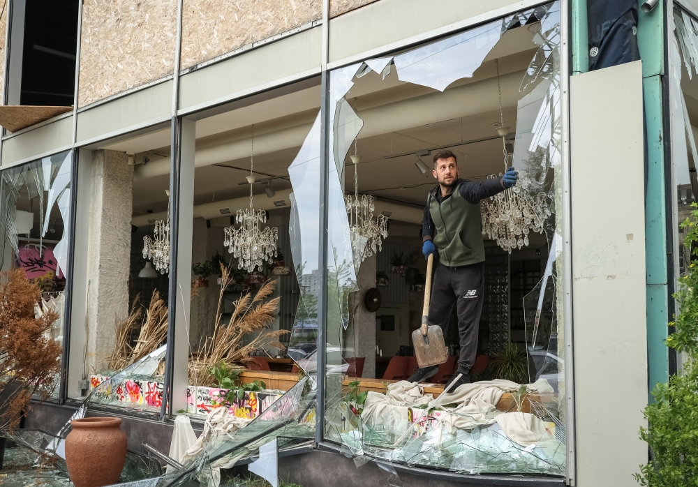 A man removes shards of glass from broken windows of a store damaged by a Russian missile strike in Kharkiv, amid Russia's attack on Ukraine on Wednesday. — Reuters