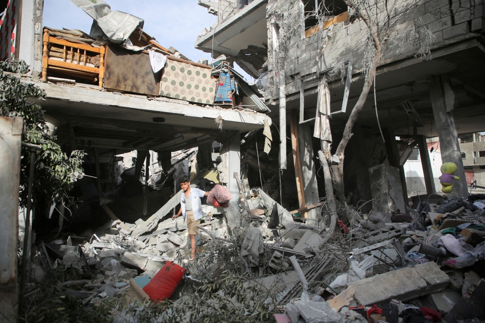 Palestinians inspect the site of an Israeli strike on a house in Rafah on Thursday. — Reuters 