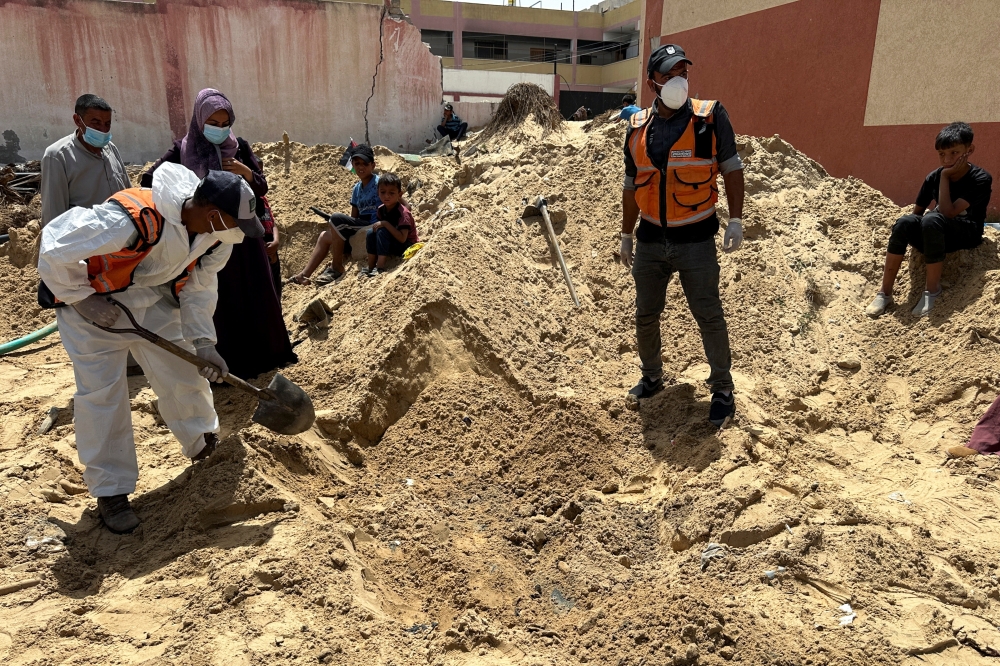 People work to recover the bodies of Palestinians killed in Khan Younis