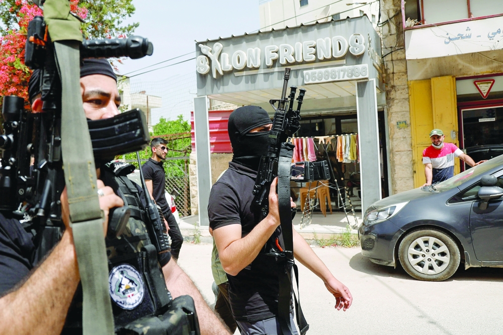 Palestinian gunmen attend the funeral of Khaled Orouq, 16, who was killed in an Israeli raid, in Jenin. — Reuters file photo