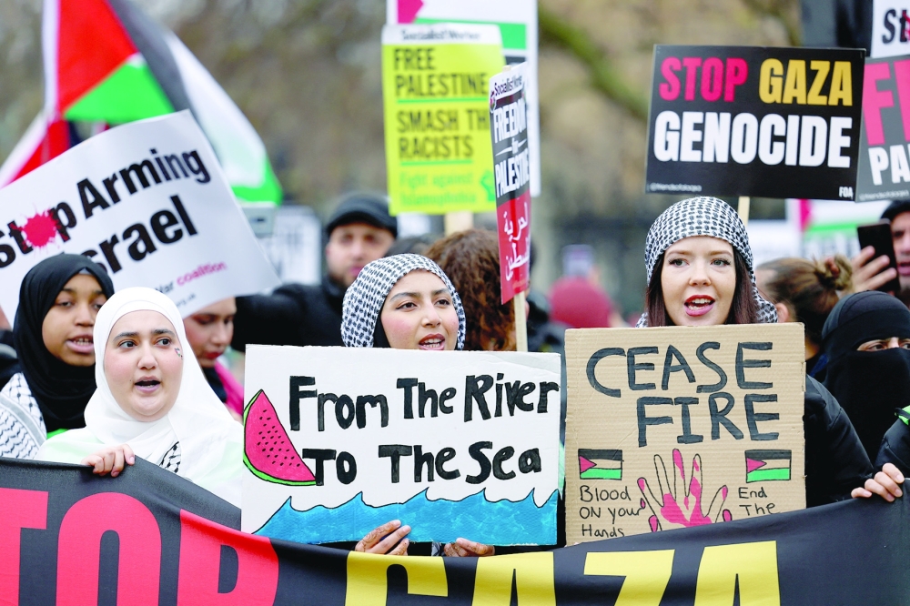 Demonstrators display placards in London, Britain, during a protest in solidarity with Palestinians in Gaza, on Saturday. - Reuters