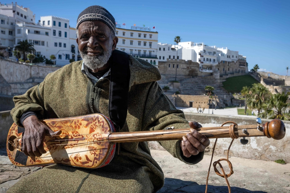 Abdellah El Gourd, a 77-year-old Moroccan legend of gnawa music, poses for a picture in the old city of Tangiers on April 23, 2024. The Moroccan city of Tangiers, which has a long history  as a haven of inspiration for American jazz musicians, will host UNESCO's International Jazz Day for the first time on April 30. Famous US pianist Randy Weston settled in Tangiers for five years after visiting 14 African countries in 1967 during a tour organised by the US State Department. (Photo by FADEL SENNA / AFP)

