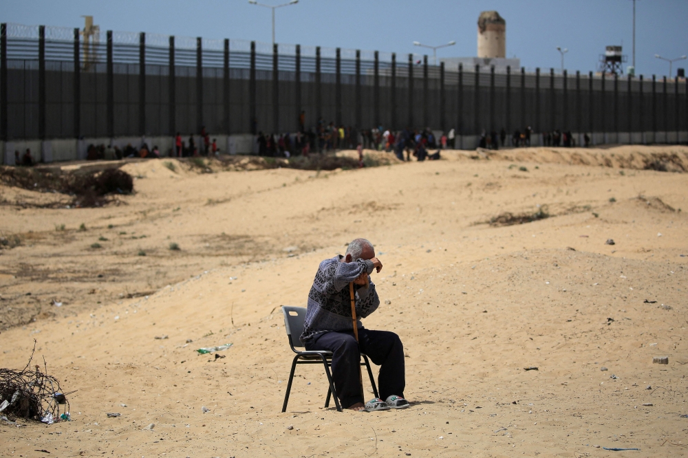 A man sits in a camp for displaced people in Rafah in the southern Gaza Strip