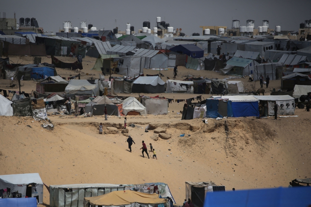 Palestinians walk in a camp for displaced people in Rafah. — AFP 