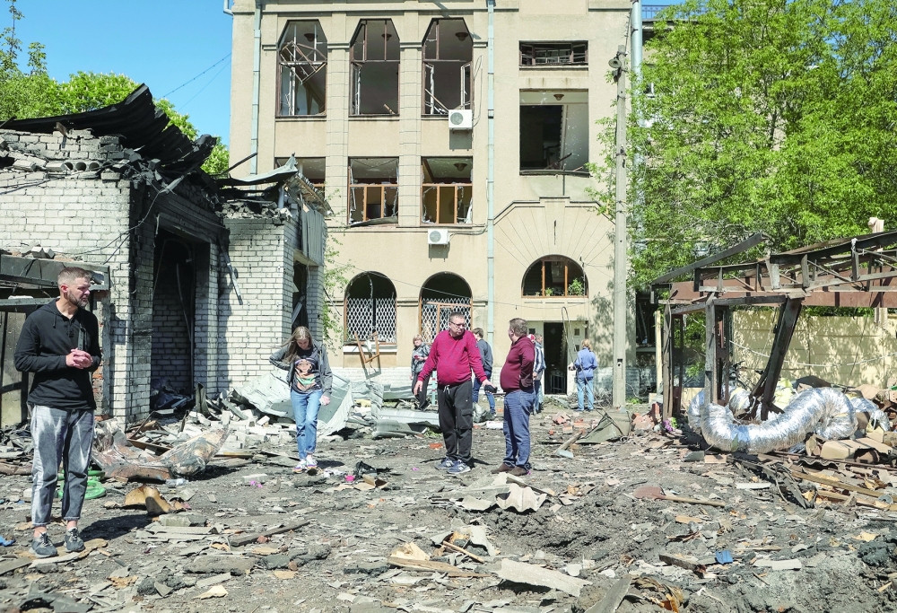 Local residents look at damage at a site of a Russian missile strike, in Kharkiv. — Reuters 