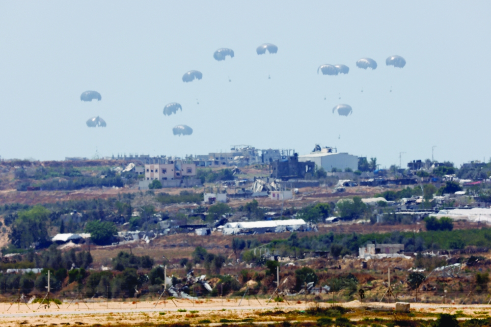 Humanitarian aid falls through the sky towards the Gaza Strip. — Reuters 