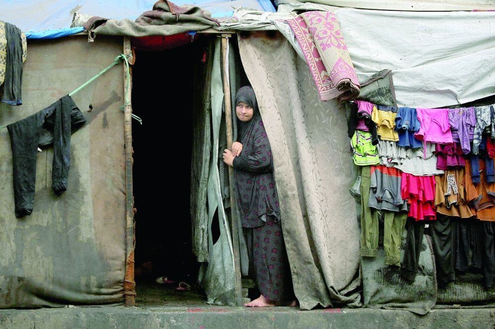 A Palestinian woman stands at the entrance of a tent in an area housing displaced people in Rafah. — AFP