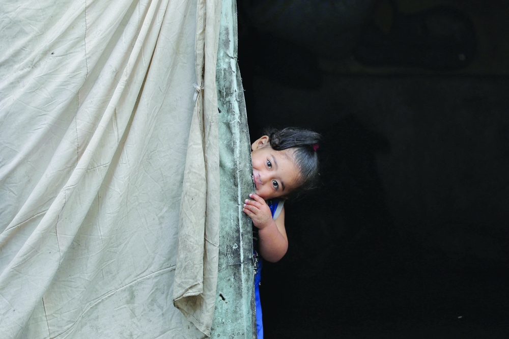 A Palestinian child peeps from the entrance of a tent in an area housing displaced people in Rafah on Tuesday. - Reuters