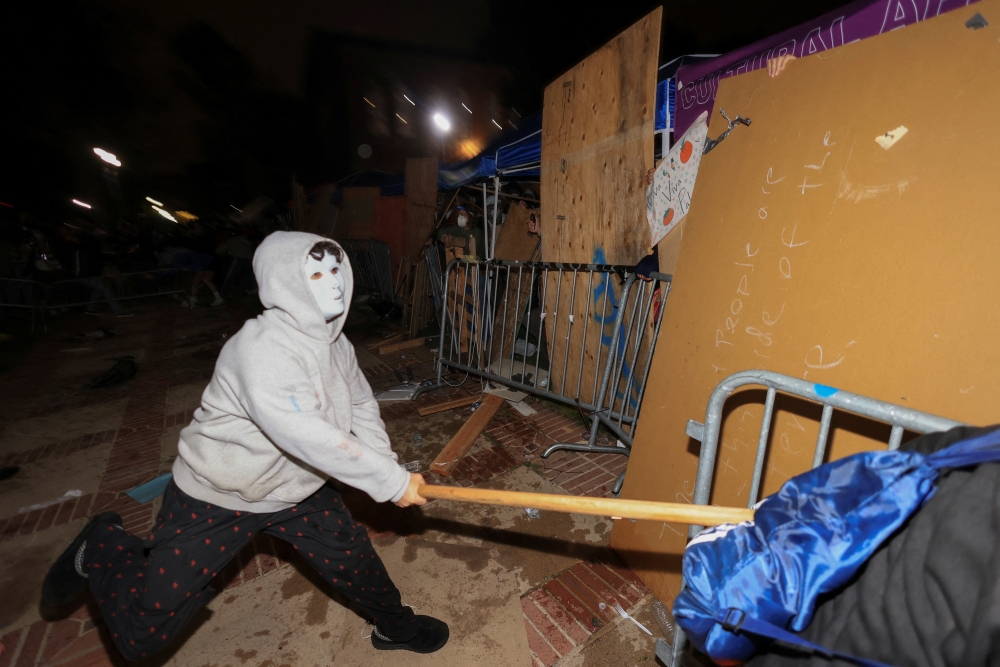 A counter-protester strikes a barricade at a pro-Palestinian encampment on the University of California, Los Angeles (UCLA) campus on Wednesday. — Reuters