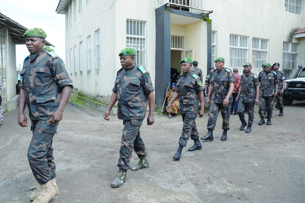 Members of the Congolese Army, sentenced to death for desertion and cowardice when fighting M23 rebels, walk in a formation as they arrive at the military courtroom for their trial in Goma. — Reuters
