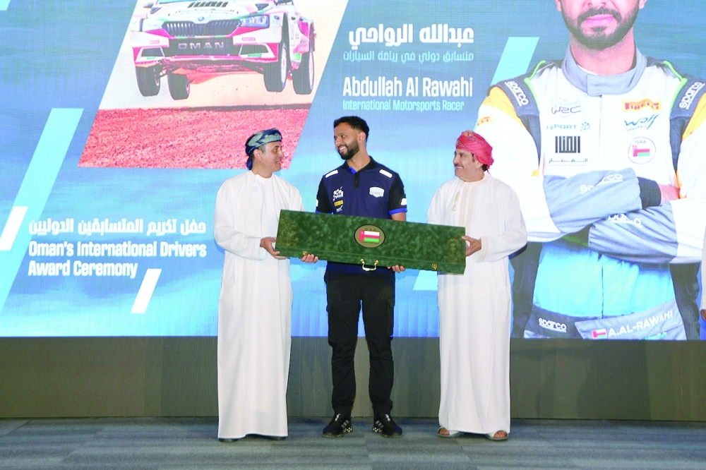 Abdullah al Rawahi (C) honoured by Salim al Maskari (R) and Jamal al Tai (L)