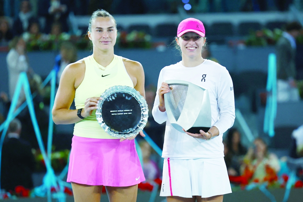 Poland's Iga Swiatek poses with the trophy and with runner up Belarus' Aryna Sabalenka.— REUTERS