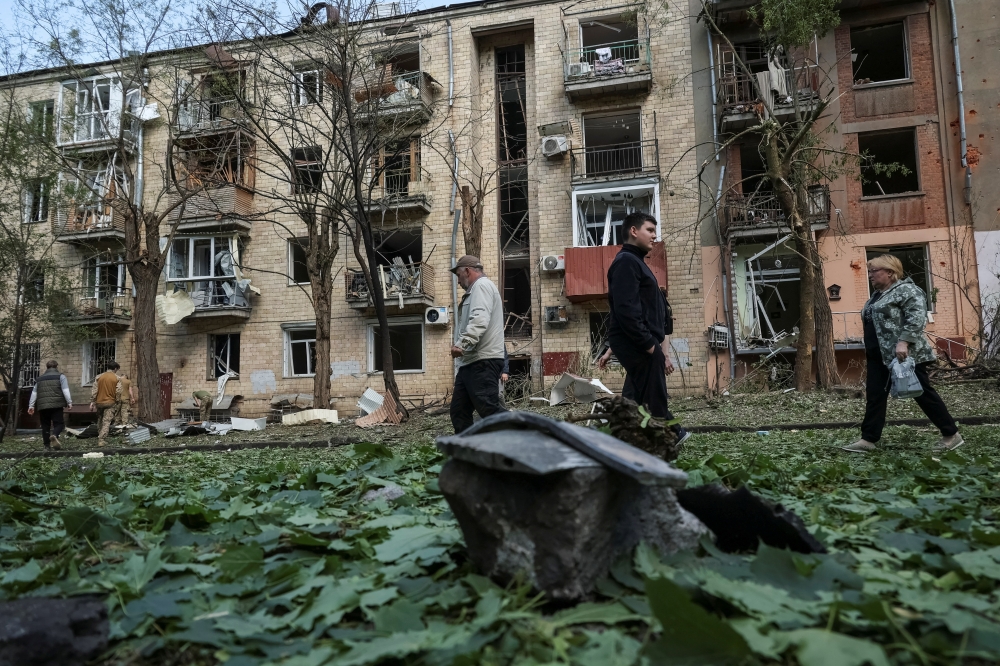 Local residents walk near an apartment building damaged by a Russian air strike, in Kharkiv. — Reuters 