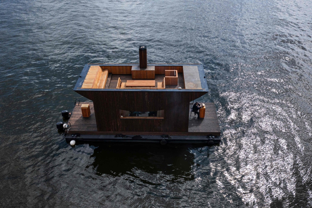 This aerial image taken on May 5, 2023 shows the "Big Branzino", a luxe floating sauna measuring 30 square metres, as it floats in the waters of the Swedish capital, Stockholm. In Sweden and Finland, some unusual saunas have been built in recent years, offering truly singular experiences. - TO GO WITH AFP STORY by Viken KANTARCI
 (Photo by Jonathan NACKSTRAND / AFP) / TO GO WITH AFP STORY by Viken KANTARCI

