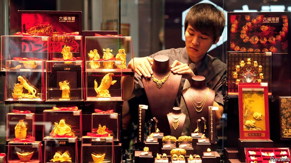 A man arranges gold displays at the gold shop in Beijing. — Reuters