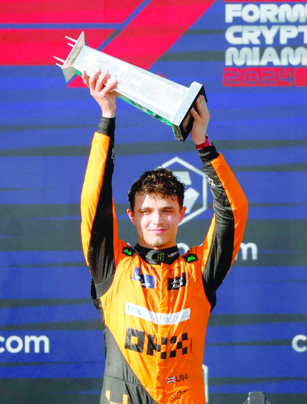 McLaren's Lando Norris celebrates winning the Miami Grand Prix on the podium with the trophy REUTERS/Marco Bello