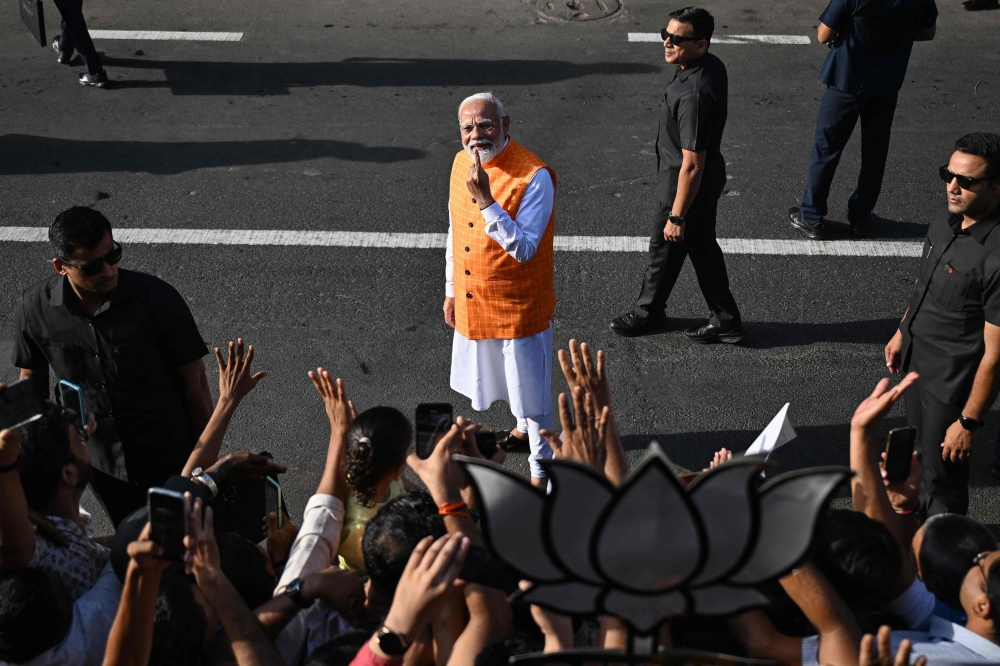 India's Prime Minister Narendra Modi, leader of the ruling Bharatiya Janata Party (BJP) displays his inked marked finger after casting his ballot at a polling booth at Ranip, Ahmedabad on May 7, 2024. (Photo by Sajjad HUSSAIN / AFP)