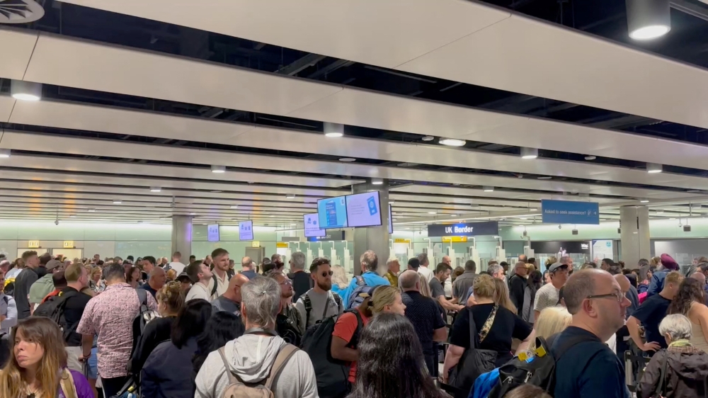 People wait in line at Heathrow airport, after the Border Force suffered a nationwide technical issue