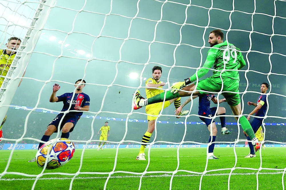 Dortmund's German defender #15 Mats Hummels (C) heads the ball past Paris Saint-Germain's Italian goalkeeper #99 Gianluigi Donnarumma (R) to score his teams first goal during the UEFA Champions League semi-final second leg football match between Paris Saint-Germain (PSG) and Borussia Dortmund, at the Parc des Princes stadium in Paris on May 7, 2024.  