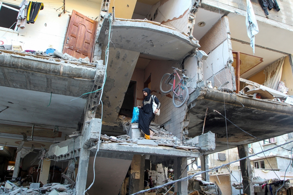 A woman walks down the stairs of a house hit in an Israeli strike in Rafah on Thursday. — Reuters