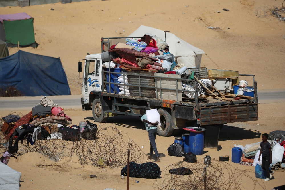 Displaced Palestinians gather their belongings on the back of a truck as they flee to a safer area in Rafah in the southern Gaza Strip 