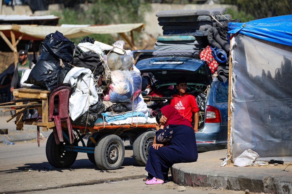 Displaced Palestinians transport their belongings as they flee to a safer area in Rafah