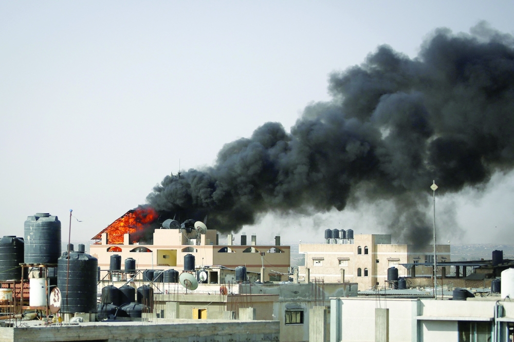 Thick, black smoke rises from a fire in a building caused by Israeli bombardment in Rafah. — Reuters 