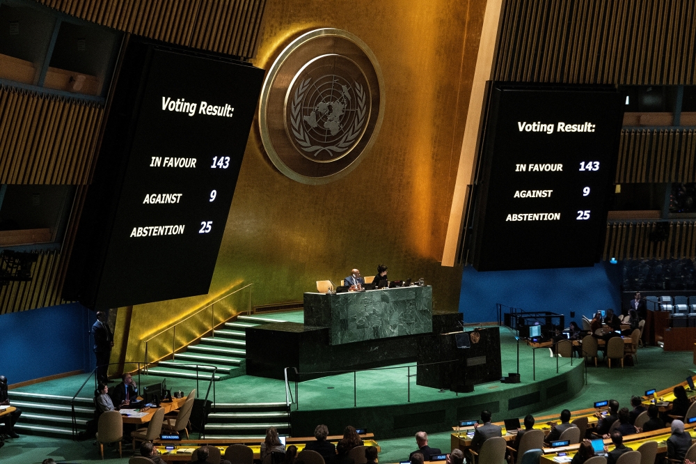 Screens show the voting result during the United Nations General Assembly vote on a draft resolutio in New York City on Friday