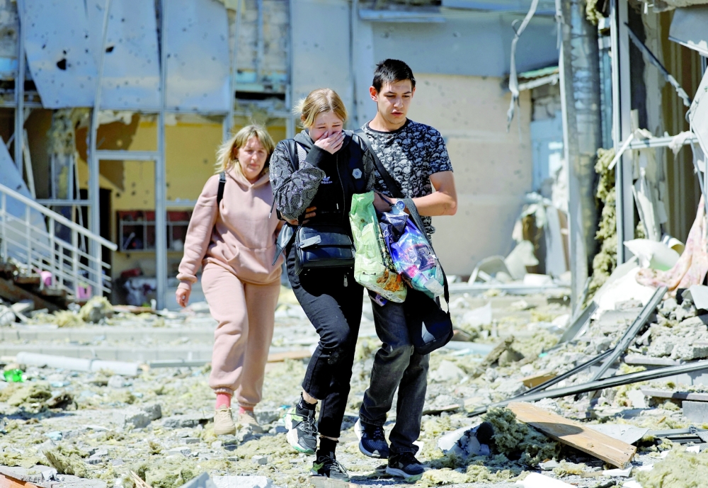 Employees leave a restaurant building hit by recent shelling, in Donetsk. — Reuters 