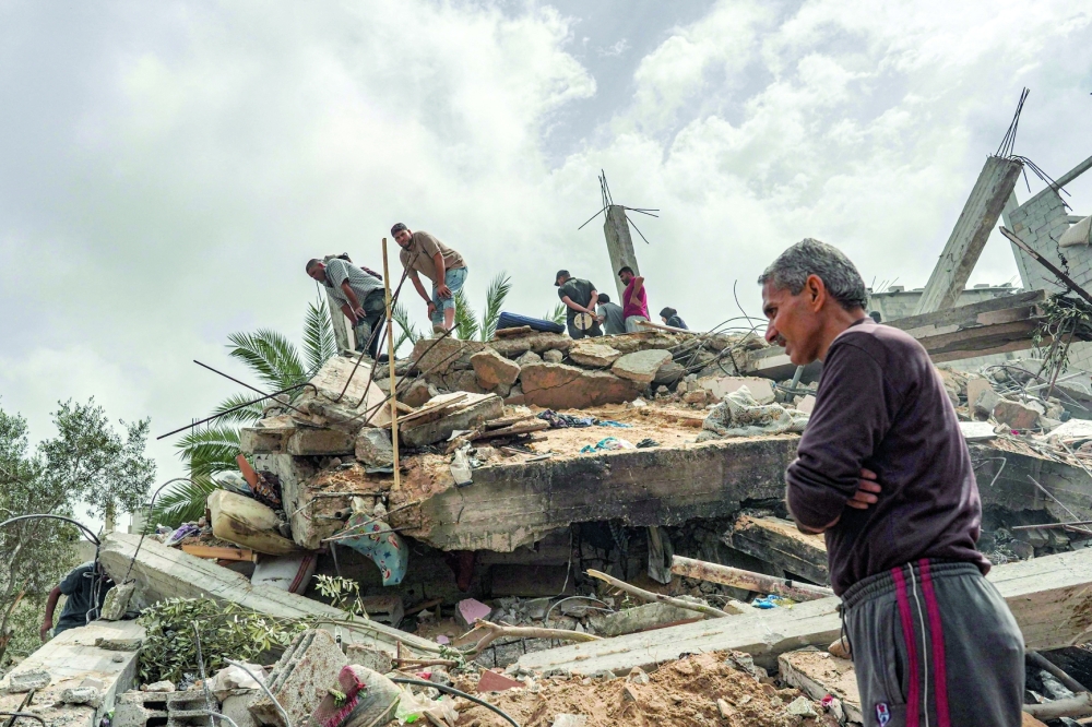 Palestinians check the rubble of a residential building destroyed in an Israeli strike in Al-Zawayda. — AFP 