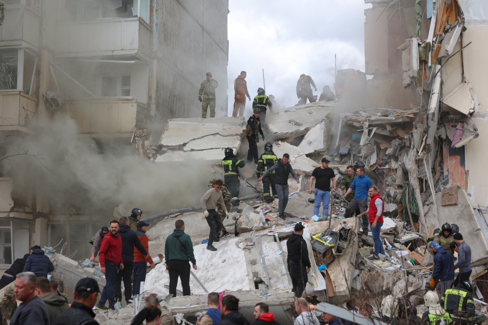 People remove debris while searching for survivors following the collapse of a section of a multi-story apartment block, in the city of Belgorod, Russia. — Reuters 