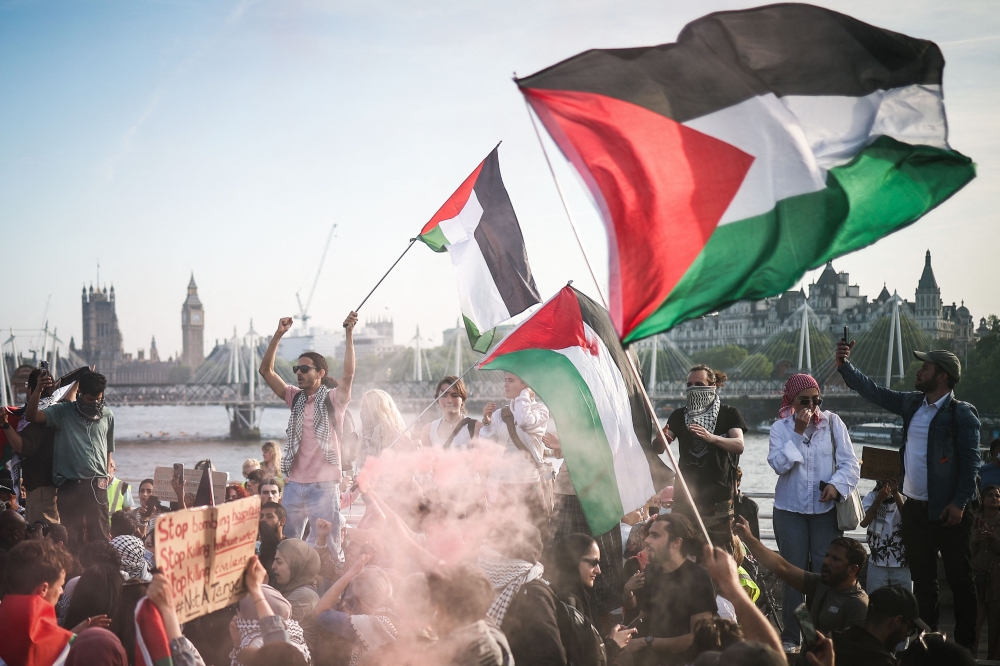 Protesters wave Palestinian flags and brandish a smoke flare during a Pro-Palestinian demonstration on Waterloo Bridge, in London, on May 11. — AFP 